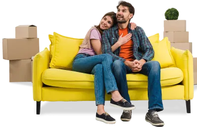 Couple zen assis sur leur canapé jaune entouré de cartons de déménagement